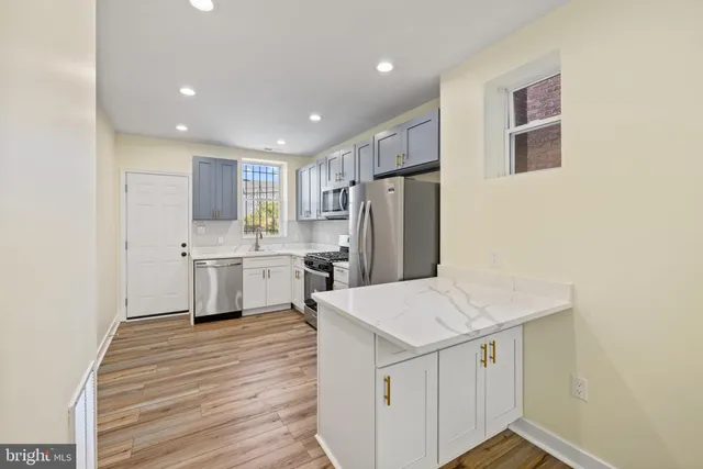 a kitchen with a sink a refrigerator and white cabinets
