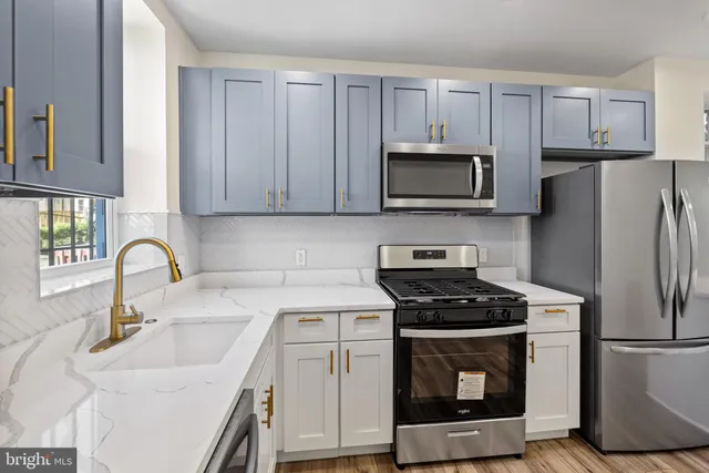 a kitchen with cabinets stainless steel appliances a sink and a stove