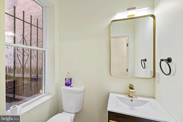 a bathroom with a sink vanity mirror and toilet