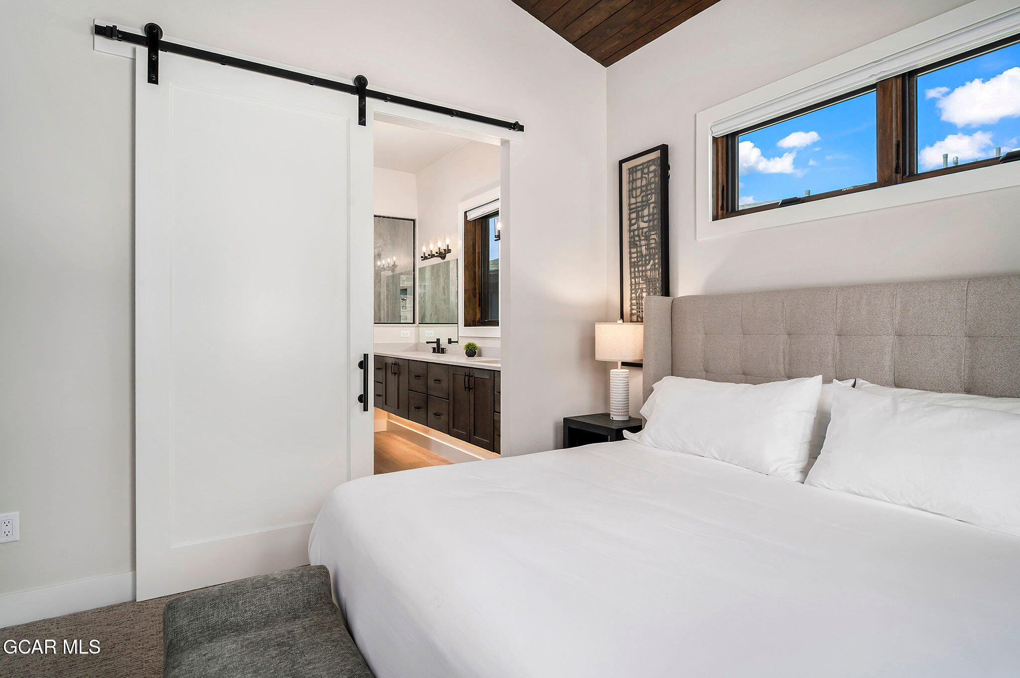 82 Game Trail Fraser, CO 80442 - Photo 19 of 51 a bedroom with a bed and a chandelier