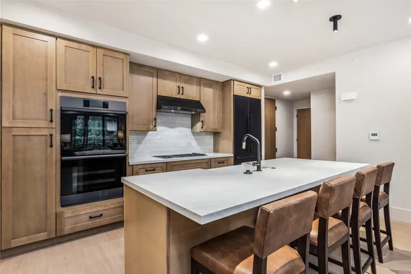 a kitchen with a table chairs refrigerator and stove