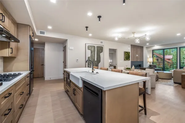 a large white kitchen with a stove a sink a dining table and chairs