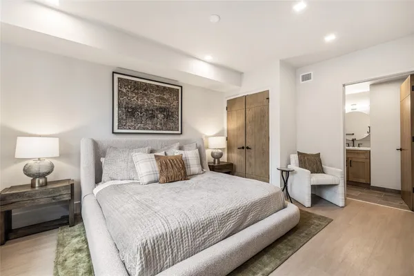 a spacious bedroom with a bed and a large mirror