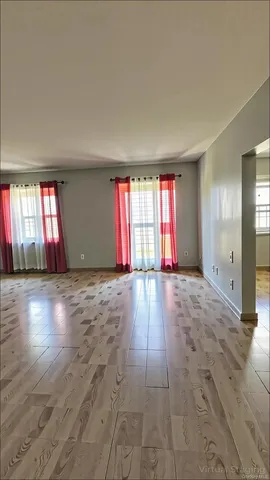 an empty room with floor to ceiling windows and chandelier