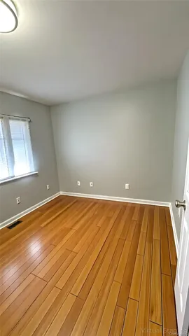 a view of empty room with wooden floor