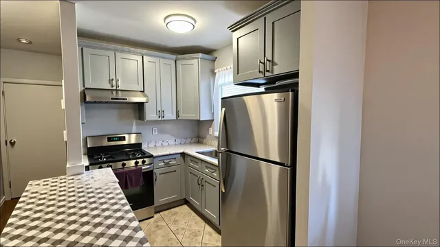 a kitchen with granite countertop a refrigerator stove top oven and sink