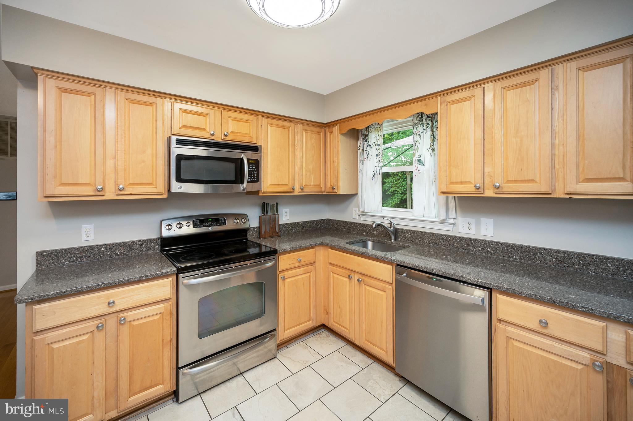 679 Cropp Road Fredericksburg, VA 22406 - Photo 16 of 39 a kitchen with granite countertop white cabinets a window a sink and a counter space