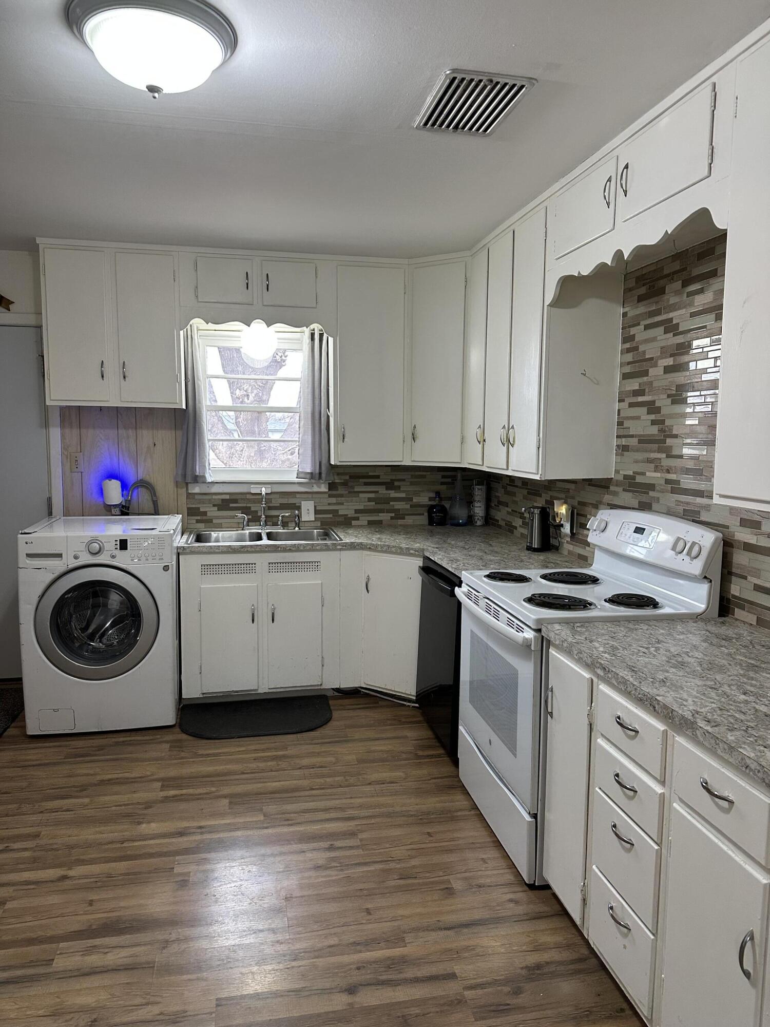 1907 38th Street Lubbock, TX 79412 - Photo 12 of 36 a kitchen with stainless steel appliances granite countertop a sink cabinets and wooden floor