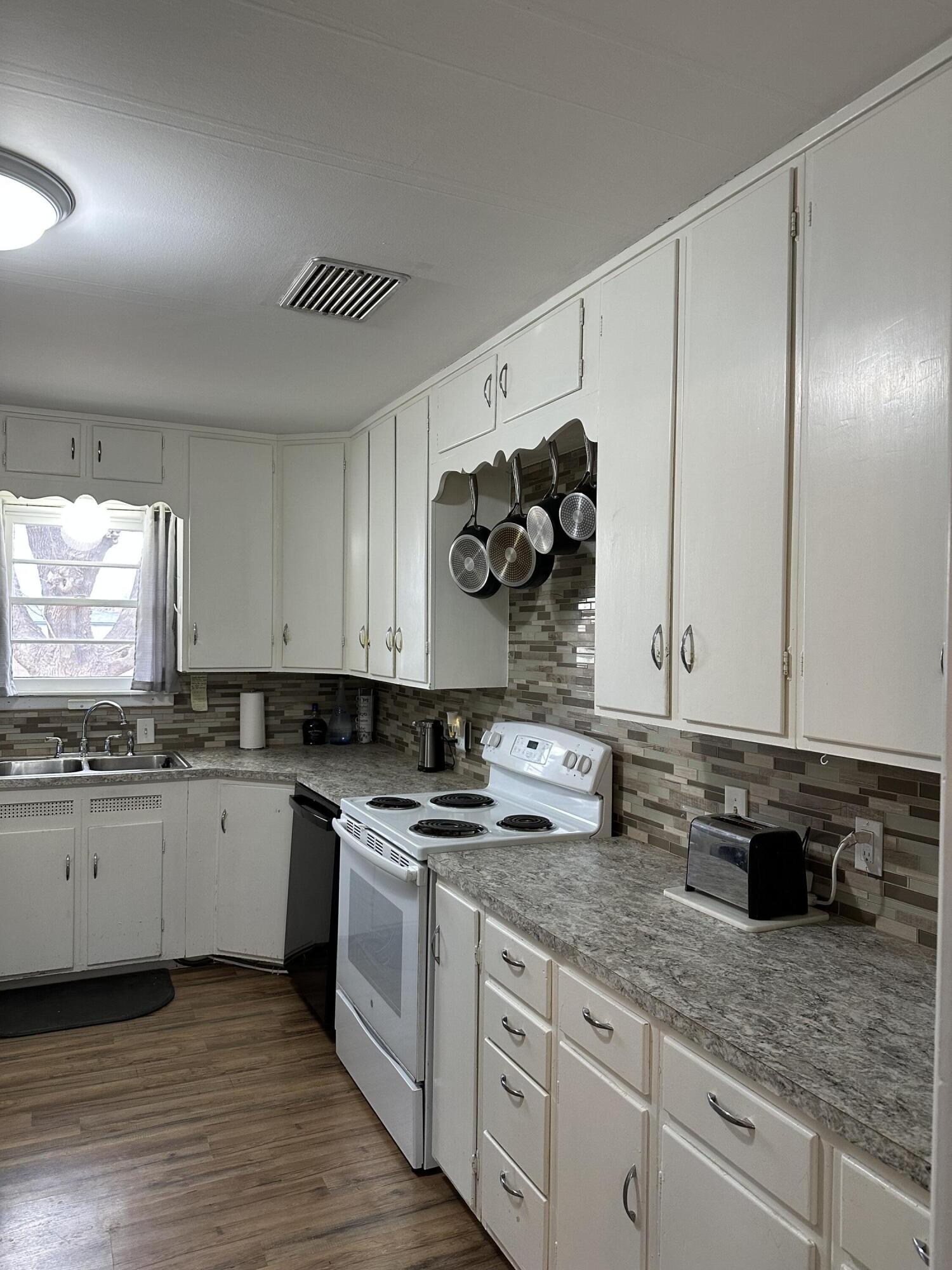 1907 38th Street Lubbock, TX 79412 - Photo 20 of 36 a kitchen with granite countertop white cabinets and white appliances