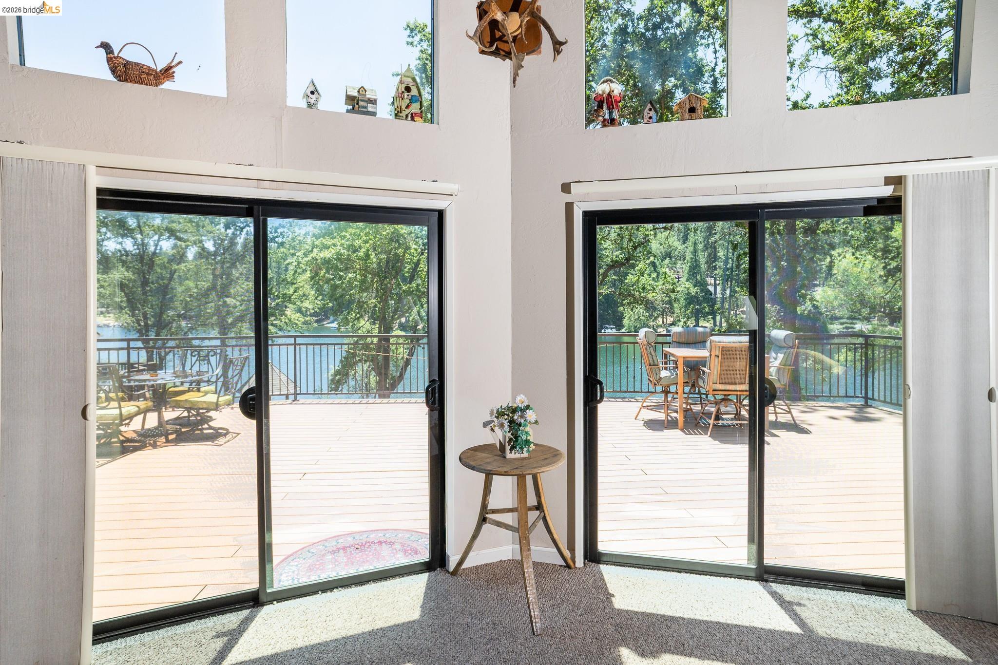 19711 Pleasantview Drive Groveland, CA 95321 - Photo 15 of 39 Dual sliding glass doors opening onto a spacious outdoor deck with black metal railings