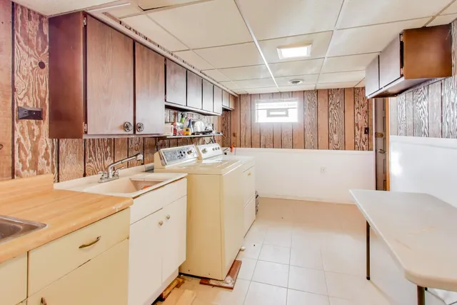 a kitchen with a sink a stove cabinets and wooden floor