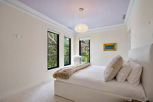 a bed sitting in a bedroom next to a window