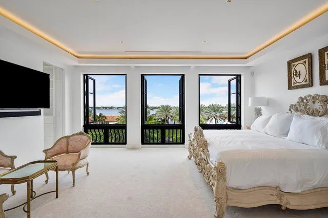 a living room with furniture a flat screen tv and a floor to ceiling window