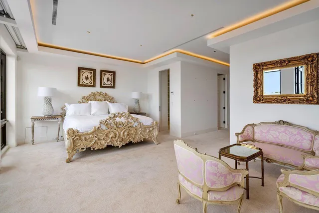 a bedroom with a bed and a chair with the wooden floor