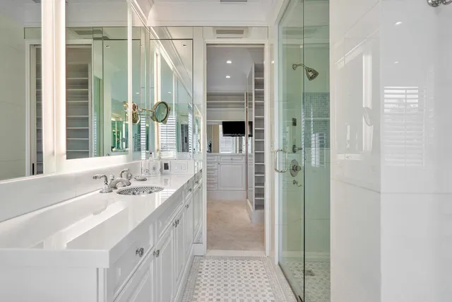 a bathroom with a double vanity sink a shower and a mirror
