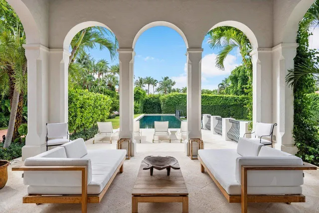 a living room with patio furniture and a large window