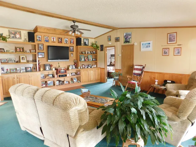 a living room with patio furniture and a flat screen tv
