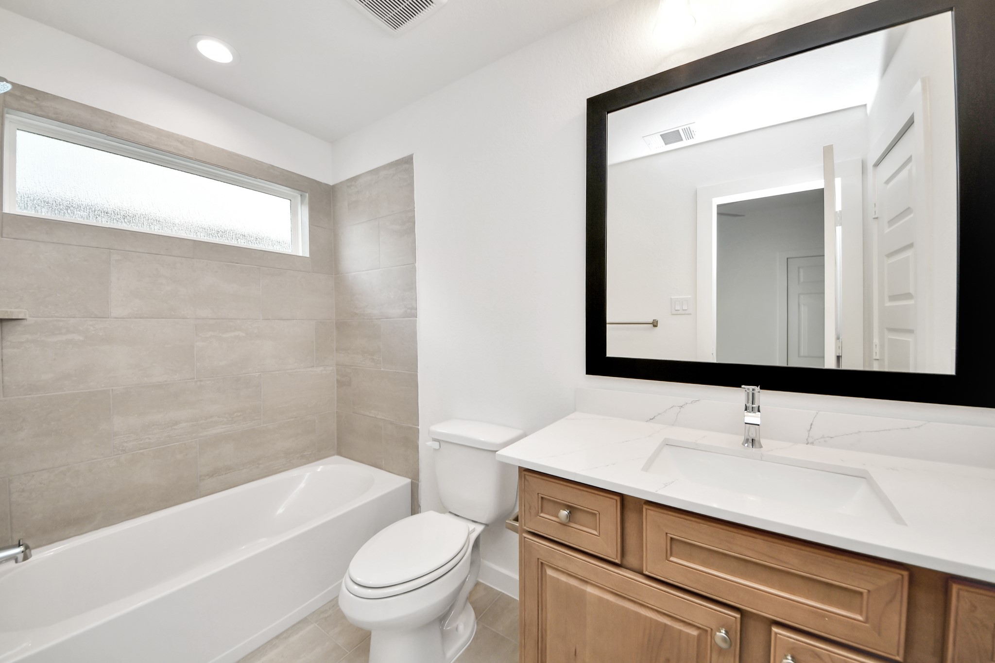 3102 Native Spg Drive Spring, TX 77373 - Photo 41 of 47 Secondary bath features tile flooring, bath/shower combo with tile surround, light stained wood cabinets, beautiful light countertop.