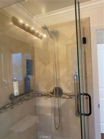 a bathroom with a shower and a glass door