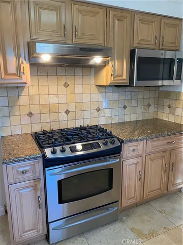 a stove top oven sitting inside of a kitchen