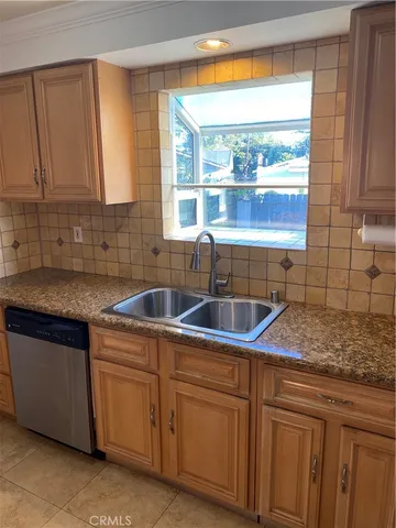 a kitchen with stainless steel appliances granite countertop a sink and a white cabinets
