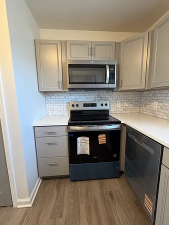 a kitchen with stainless steel appliances a stove microwave and sink