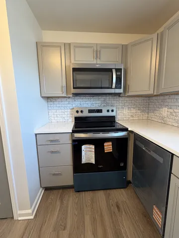 a kitchen with stainless steel appliances a stove microwave and sink