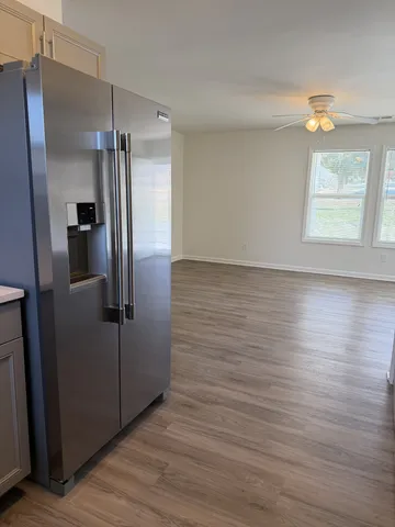 a view of a refrigerator in kitchen and wooden floor