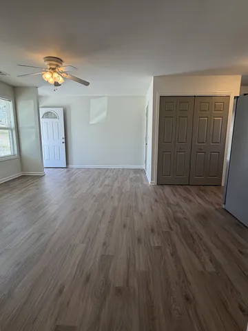 a view of a livingroom with wooden floor and a ceiling fan