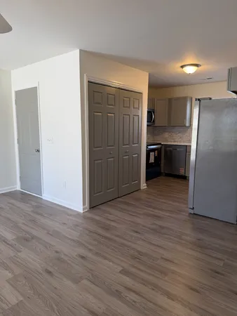 a view of a kitchen with a refrigerator a stove top oven and cabinets