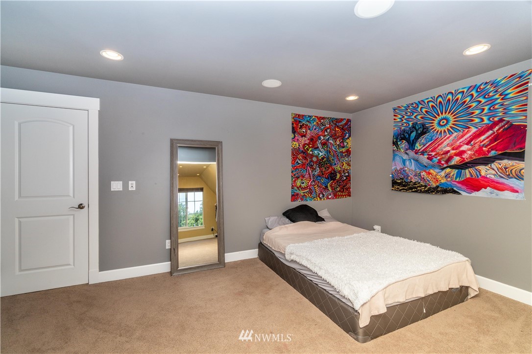 27515 Rose Road Arlington, WA 98223 - Photo 16 of 31 a bedroom with a large bed and a painting on the wall