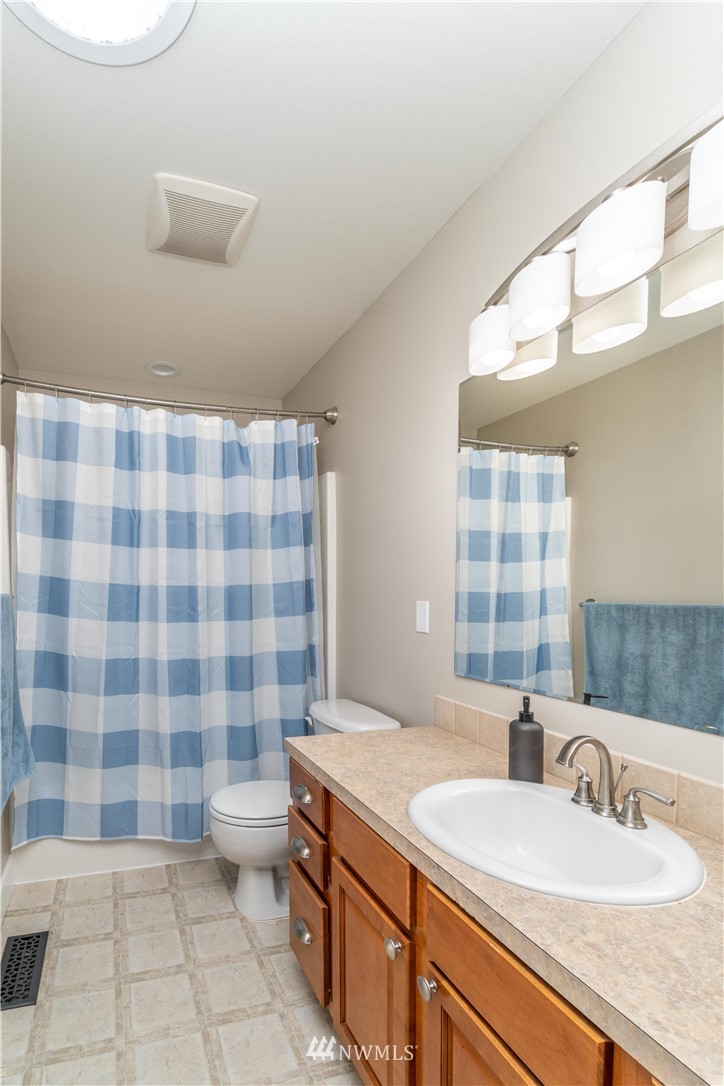 27515 Rose Road Arlington, WA 98223 - Photo 17 of 31 a bathroom with a sink a toilet a mirror and shower