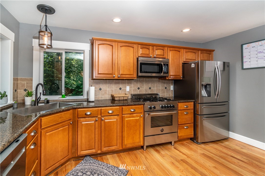 27515 Rose Road Arlington, WA 98223 - Photo 8 of 31 a kitchen with stainless steel appliances granite countertop a stove a sink dishwasher a refrigerator and a microwave oven with wooden floor
