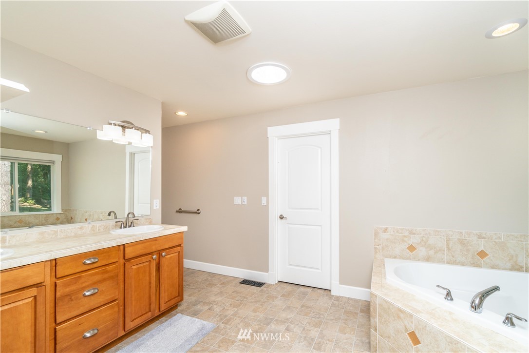 27515 Rose Road Arlington, WA 98223 - Photo 10 of 31 a spacious bathroom with a tub sink and mirror