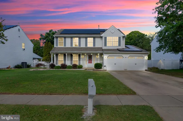a front view of a house with a garden and yard