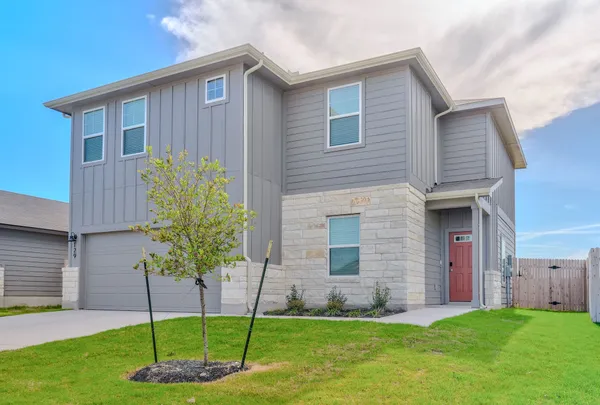 a kitchen with stainless steel appliances granite countertop a refrigerator a stove a sink and white cabinets