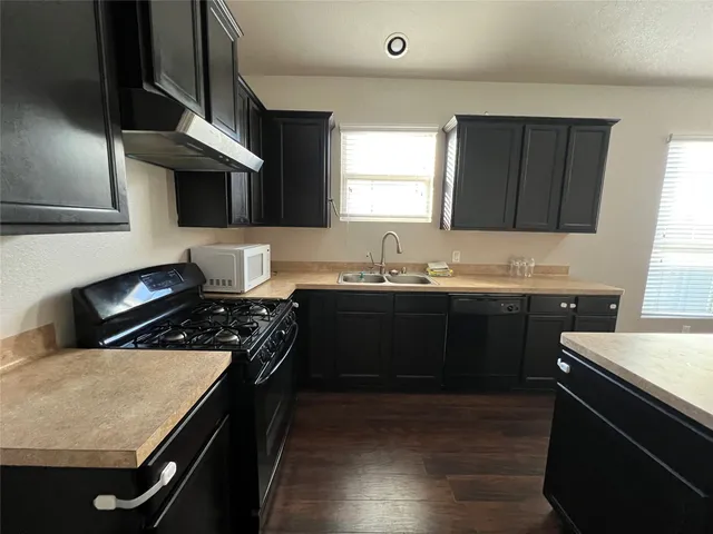 a kitchen with a sink a stove and cabinets
