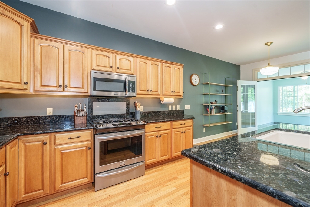97 High Pine Circle, Unit 97 Wilbraham, MA 01095 - Photo 7 of 37 a kitchen with stainless steel appliances granite countertop a stove a sink and a microwave