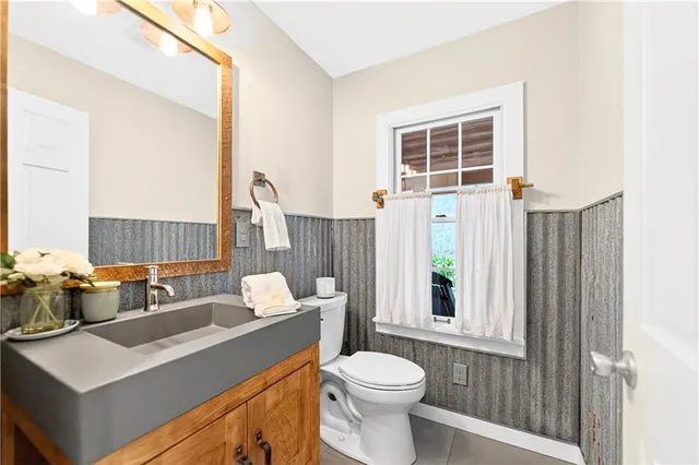 a bathroom with a sink vanity mirror and toilet
