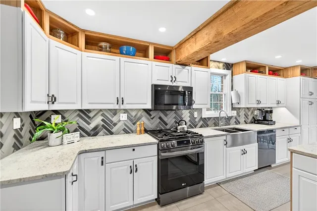 a kitchen with stainless steel appliances granite countertop a stove a sink and a microwave