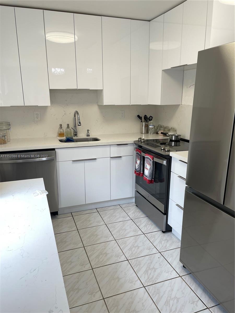 Kings Point Delray Beach, FL 33484 - Photo 9 of 69 a kitchen with stainless steel appliances granite countertop a stove a sink and a refrigerator