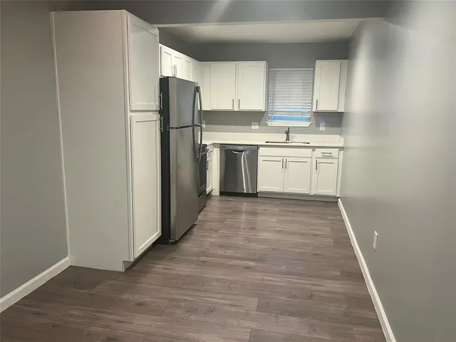 a kitchen with a white refrigerator freezer a sink and dishwasher