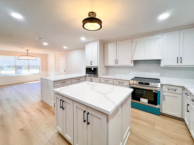 a kitchen with a stove sink and cabinets