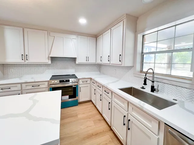 a kitchen with granite countertop white cabinets and white appliances