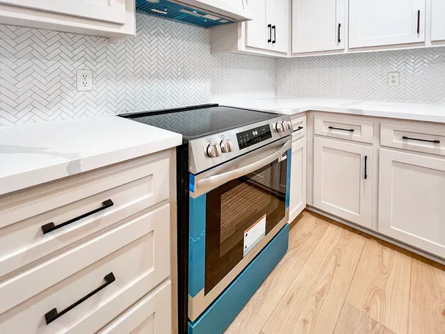 a stove top oven sitting inside of a kitchen