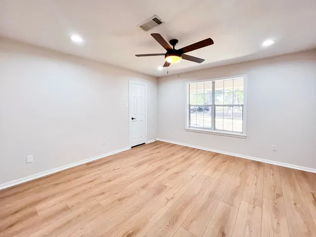 wooden floor in an empty room with a window