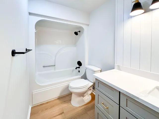 a bathroom with a granite countertop toilet a sink and a bathtub