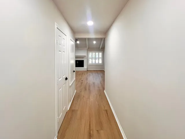 a view of a hallway with wooden floor