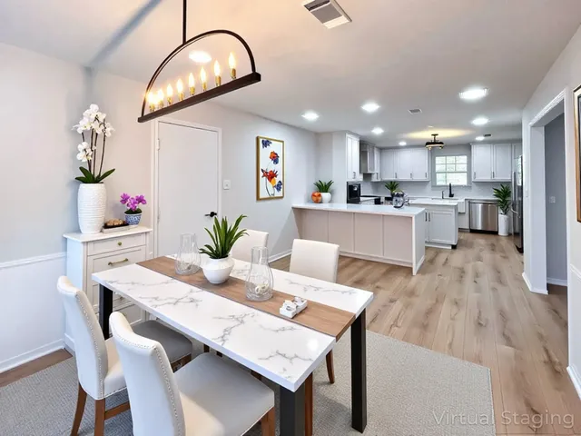 a view of a dining room and livingroom with furniture wooden floor a chandelier