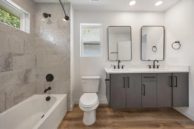 a bathroom with a double vanity sink mirror and toilet